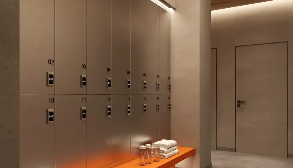Interior rendering of a changing room with lockers, a bench and warm indirect lighting.