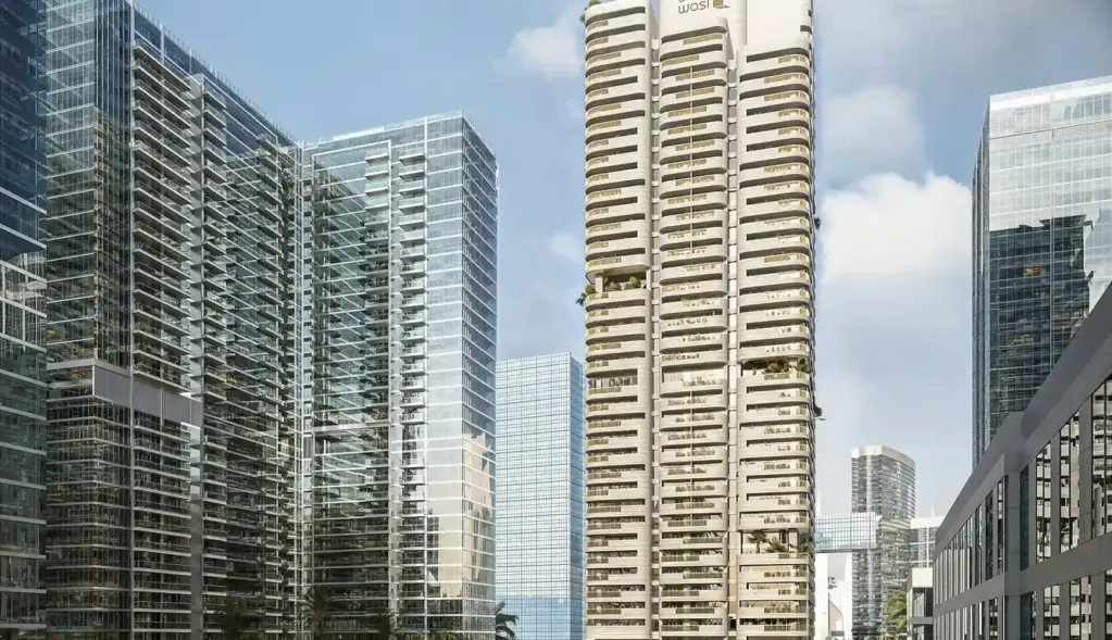 A residential tower stands over landscaped pathways and planted community spaces.