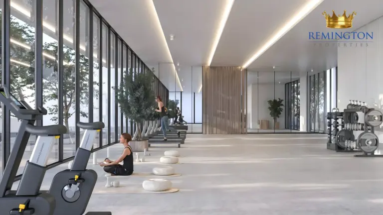 Fitness room with cardio equipment beside full-height windows