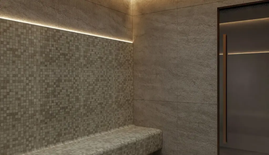 Stone-finish steam room with a built-in bench and soft lighting