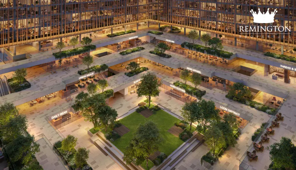 Central courtyard with planted areas, seating and illuminated office façades at dusk